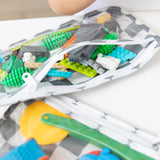 Close-up of Bumkins Clear Travel Bag 3 Pack: Charcoal Check, filled with colorful blocks and toy tools on a white table.