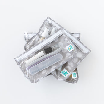 Three bags from Bumkins The Playdate Planner Deluxe 5-Piece Set: Lunar Phase are stacked on a white background, holding toiletries.