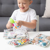 Smiling child in a white shirt plays at a table with Bumkins Wet Bag + Clear Travel Bag 3 Pack Set: Disney Mickey & Friends Varsity.