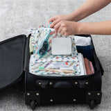 Hands pack bags from Bumkins The Chaos Coordinator Deluxe 5-Piece Set: Disney Mickey & Friends Varsity into a suitcase on a gray carpet.