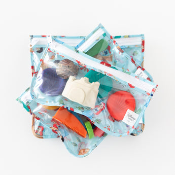 Bumkins Clear Travel Bag 3 Pack: Disney Princess Ariel is stacked on a white background, holding colorful beach-themed toys.