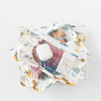 Three stacked bags from Bumkins The Outfit Organizer Essential 5-Piece Set: Winnie and Friends hold snacks on a white background.