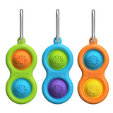 Three Simpl Dimpl poppers by Fat Brain Toy Co feature green, blue, and orange bubbles with metal clips for tactile stimulation.