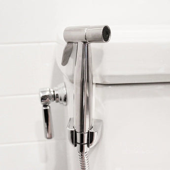 Close-up of Bumkins Cloth Diaper Sprayer shown mounted to a toilet white toilet.