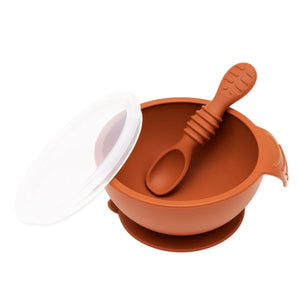 Bumkins Silicone First Feeding Set: Clay includes a bowl with suction bottom, a matching spoon, and a transparent lid.
