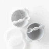 Bumkins Silicone First Feeding Set: Gray sits by another bowl and spoon set on a white background.