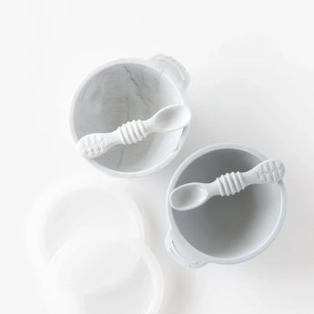 Bumkins Silicone First Feeding Set: Gray sits by another bowl and spoon set on a white background.