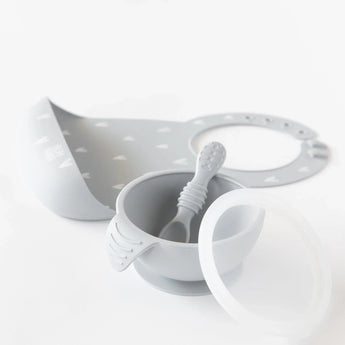 Bumkins Silicone First Feeding Set: Gray sits in front of a gray silicone bib on a white background.