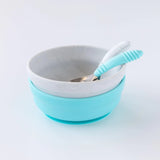 Bumkins Silicone Grip Bowl: Marble sits stacked on top of a blue bowl, with two spoons inside, on a white background.