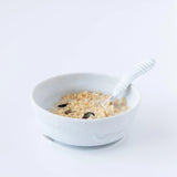Bumkins Silicone Grip Bowl: Marble with cereal, milk, and fruit, with a matching spoon on a white background.