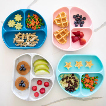 Bumkins Silicone Grip Dish: Marble sits among 3 other plates with toddler meals on a marble background.