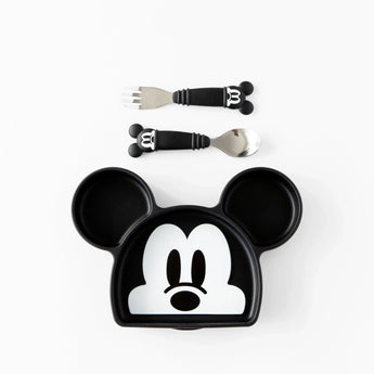 Bumkins Silicone Grip Dish: Mickey Mouse sits below a set of matching utensils on a white background.