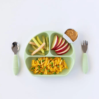 Bumkins Silicone Grip Dish: Sage with mac & cheese, apple, and veggie sticks, a cup of peanut butter, and utensils on a white background.
