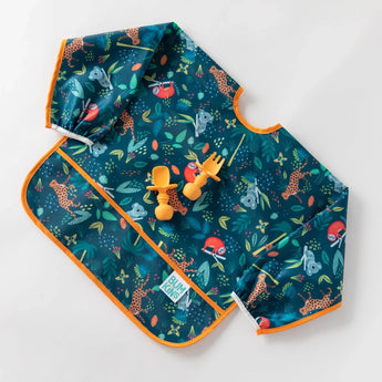 A jungle-themed bib with orange silicone utensils on top from Bumkins Ultimate Gift Set - Jungle & Animal Prints on a white background.