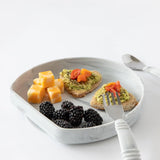 Bumkins Silicone Grip Plate: Marble with cheese, avocado toast, and blackberries with a fork and knife nearby on a white background.