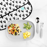 Bumkins Silicone Grip Tray: Gray holds beans and rice, broccoli, and fruit next to a heart-print bib and utensils on a marble background.