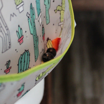 Close-up of berries in the pocket of a Bumkins SuperBib®: Cacti.