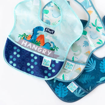 Bumkins SuperBib® 3 Pack: Hangry, Dinosaurs, Blue Tropic is fanned out on a white background.