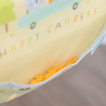 Close-up of orange snack crackers in the pocket of a yellow Bumkins SuperBib® 3 Pack: Happy Campers.