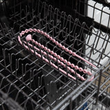 Bumkins Silicone Accessory Tether 2-Pack: Pink sits in the top rack of an open dishwasher.
