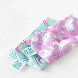Bumkins Reusable Snack Bag, Small 2-Pack: Rainbows & Unicorns lays stacked on a white background.
