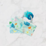 Bumkins Reusable Snack Bag, Small 2-Pack: Ocean Life & Whale Tail holds a blue teething toy on a marble background.