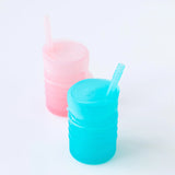 Bumkins Silicone Straw Cup with Lid: Blue sits in front of a pink cup on a white background.