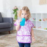 A child with curly hair in a unicorn bib drinks from a Bumkins Silicone Straw Cup with Lid: Blue.