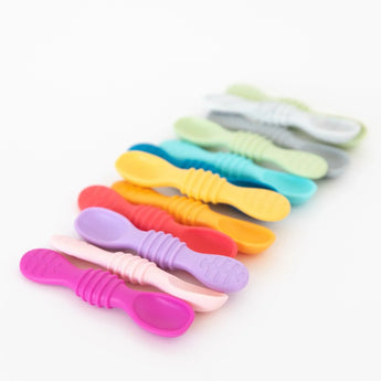 Bumkins Silicone Dipping Spoons 3 Pack: Lollipop lays among other silicone spoons on a white background.
