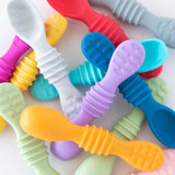 A pile of silicone spoons, including Bumkins Silicone Dipping Spoons 3 Pack: Gumdrop, on a white background.