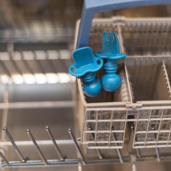 Bumkins Silicone Chewtensils®: Dark Blue sits in the utensil compartment of an open dishwasher.