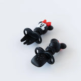 Bumkins Silicone Chewtensils®: Minnie Mouse are displayed on a white background with one face-down, showcasing sensory bumps on the back.