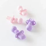 Bumkins Silicone Chewtensils®: Lavender sits next to a set of pink silicone utensils on a white background.