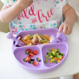 Close-up of a child in a high chair eating pasta and veggies from a purple divided plate with Bumkins Silicone Chewtensils®: Lavender.