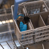 Bumkins Spoon + Fork: Dark Blue sits in the utensil compartment of an open dishwasher.