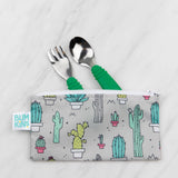 Bumkins Spoon + Fork: Jade peeks out from a gray cactus-patterned pouch on a marble background.