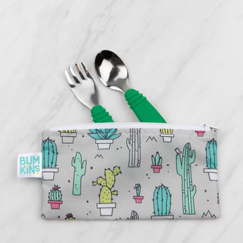 Bumkins Spoon + Fork: Jade peeks out from a gray cactus-patterned pouch on a marble background.