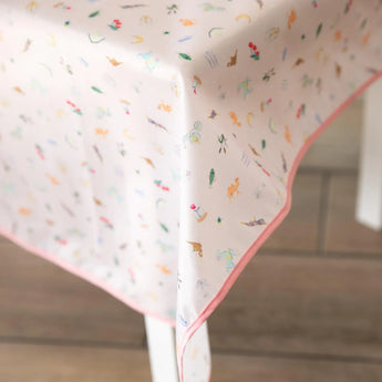 Close-up of Bumkins Splat Mat: Princess Magic covering a table on a wood floor.