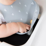 Close-up of a baby in a Bumkins Silicone Bib: Hearts reaching for food in the front pocket.