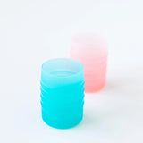 Bumkins Silicone Starter Cup: Blue sits in front of a pink cup on a white background.