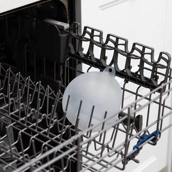 Bumkins Silicone Stretch Lid for Grip Bowl sits in the top rack of an open dishwasher.