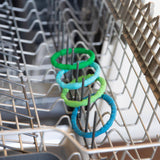 Bumkins Silicone Teething Rings 4 Pack: Summer sits in the top rack of an open dishwasher.