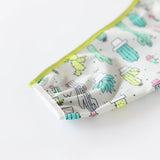 Close-up of Bumkins Sleeved Bib: Cacti on a white background, with focus on the white elastic cuff on the sleeve.