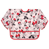 Bumkins Sleeved Bib: Minnie Mouse is made of pink waterproof fabric with a Minnie Mouse design, red trim, and front pocket.