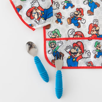 Close-up of Bumkins Sleeved Bib: Super Mario™ Classic on a white background with blue utensils.