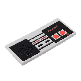 Bumkins Silicone Teether: NES™ Controller is a gray and black retro-style food-safe silicone teether modeled after a video game controller.