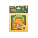 Bumkins Silicone Teether: Zelda™ Link is shown in a green and yellow packaging box with a clear front window displaying the teether.
