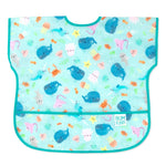 Bumkins Junior Bib: Ocean Life features teal waterproof fabric with a sea creature design, front pocket, and adjustable neck closure.