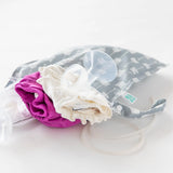 Bumkins Wet Bag: Arrow filled with cloth diapers and breast pump parts lays on a white background.
