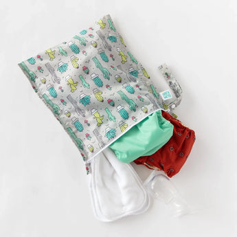 Bumkins Wet Bag: Cacti holds cloth diapers, white cloths, and breast pump parts on a white background.